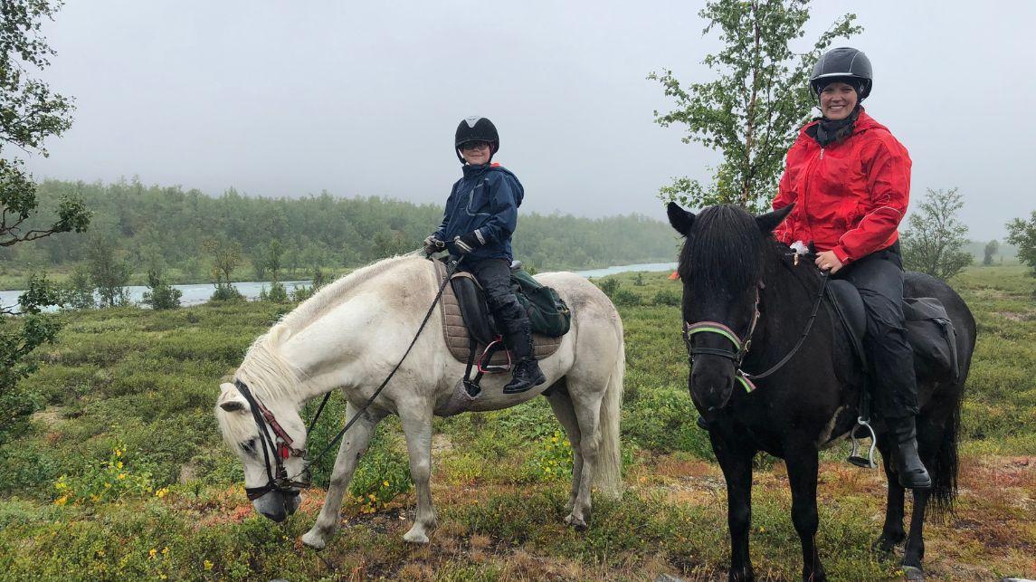 Jenny Pyykkönen and her daughter riding on horses in north Sweden